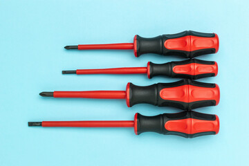 Set of Insulated Screwdrivers on Light Blue Background for Electrical Work Safety
