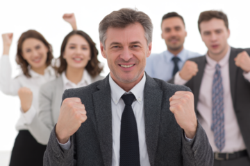 A group of diverse business professionals celebrating a successful achievement with raised fists and smiles.