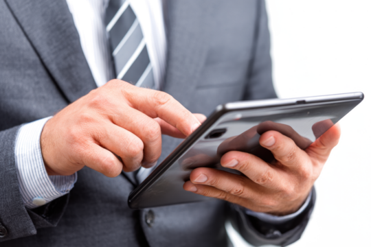 A person in a suit is using a tablet, likely for business or work purposes.