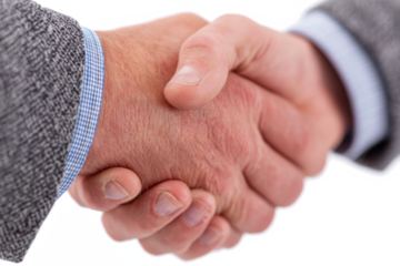 Close-up of two business professionals shaking hands, symbolizing agreement and partnership.