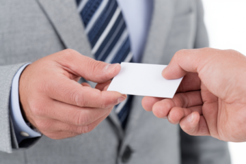 Business exchange: A man in a suit hands a blank business card to another person.