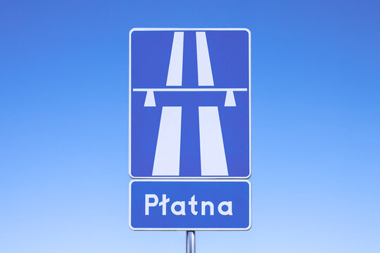 Polish road sign reading "a toll motorway" on a blue sky background.