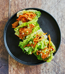ginger soy shredded pork lettuce cups topped with shredded carrot and green onion