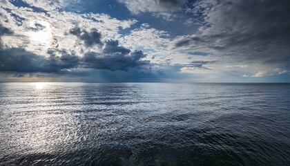 Fototapeta premium Calm Silvery Water Ripples Under A Dramatic Heavy Sky Over The Kyiv Sea Ukraine The Horizon Is A Thin Line Between The Vast Water And Clouds