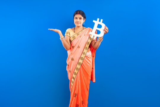 Indian Woman in Saree Holding Bitcoin Symbol on Blue Background