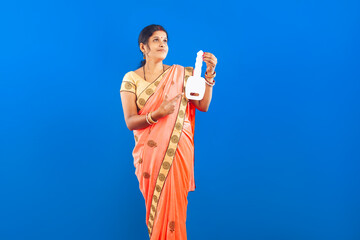 women in traditional saree pointing index finger towards car key symbol in blue background