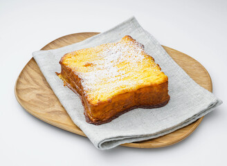 Brioche French Toast Topped with Powdered Sugar on a Wooden Plate, Isolated on White Background side view of quick lunch, and breakfast