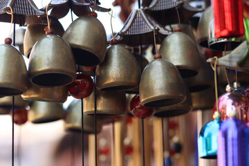 Souvenirs in the form of hanging golden bells, close-up. Souvenir market. Hanging bells used for home decoration. Group of bells with selective focus