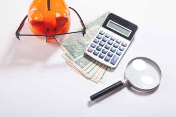 piggy bank with money and a calculator on the table