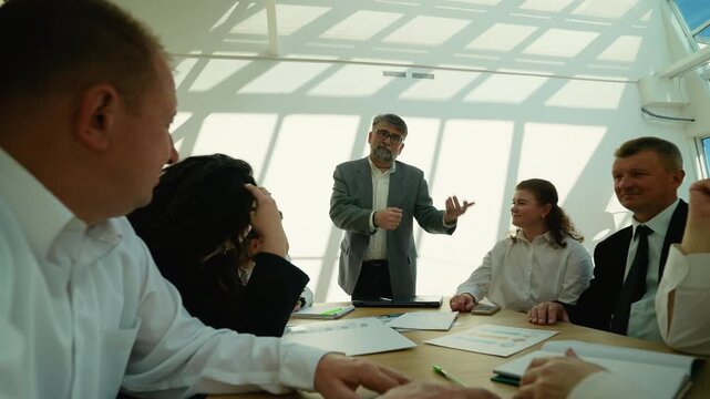 Confident senior ceo leading corporate business meeting in office