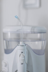 A home water flosser for teeth and oral care, placed in a bathroom interior. Concept: a modern and efficient solution for daily oral hygiene.