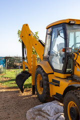 Yellow excavator on rural construction site