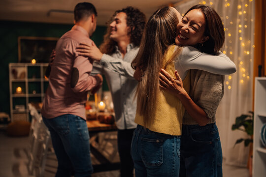 Friends embracing at thanksgiving dinner party, celebrating with loved ones - Powered by Adobe