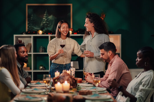 Friends giving thanks during christmas celebration dinner party - Powered by Adobe
