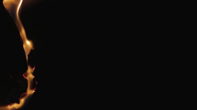 Burning paper, glowing edge of paper on a black background. Mockup for your logo. Wide angle horizontal wallpaper or web banner. flame effects for overlay designs or screen blending mode to make high.