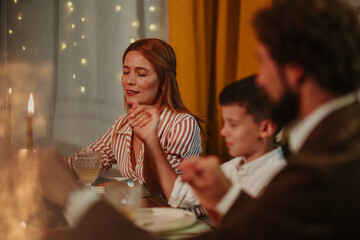 Family praying before christmas dinner at home