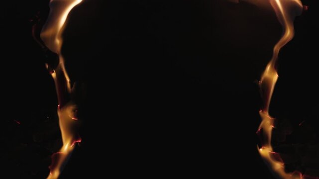 Burning paper, glowing edge of paper on a black background. Mockup for your logo. Wide angle horizontal wallpaper or web banner. flame effects for overlay designs or screen blending mode to make high.