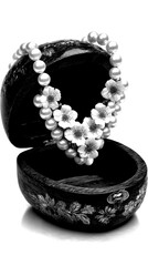 Elegant pearl necklace with floral accents displayed in a wooden jewelry box