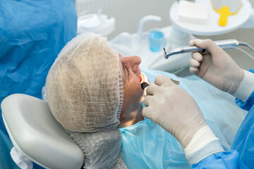 dentist surgeon installing an implant to an elderly woman. Prosthetic dentistry, false teeth