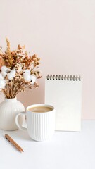 Still life of coffee, dried flowers, and a notepad