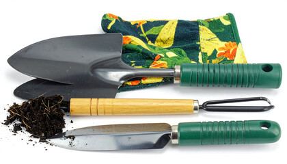 Gardening tools with green and wooden handles on white surface, floral glove and soil indicating recent use.