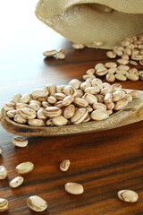 Carioca beans in a wooden spoon with back natural light.