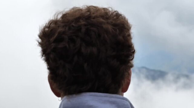 Chico mirando a la monta&ntilde;a con niebla