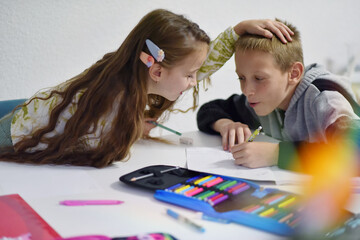 Brother and sister doing homework together at home