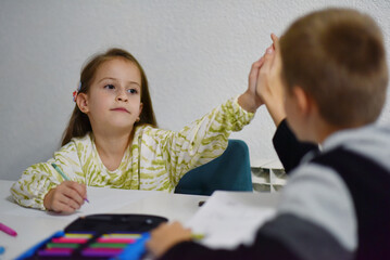 Brother and sister doing homework together at home