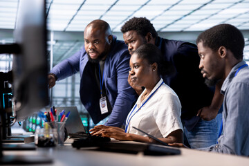 Team of engineers reconfiguring server farm to optimize it for data processing requirements of...