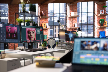 Empty graphic design studio with photo editing setup and AI chat software. Monitors display digital retouching software, color correction and enhancement tools for image processing.