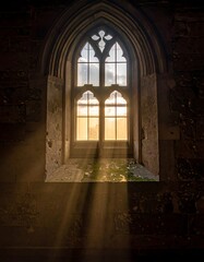Sunlight streams through a gothic window