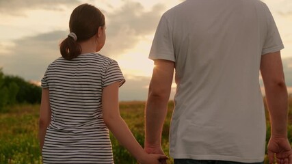 Father daughter walk hand in hand in summer park. Dad daughter stroll together in nature. Happy family in nature. Parents dad daughter celebrate happy childhood. Family picnic travel healthy lifestyle