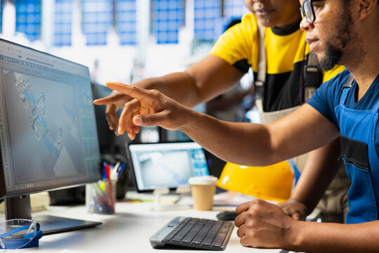 Black team of manufacturing plant employees fixing errors and debugging technical issues, working together in the assembly line of solar panels at the industrial factory. Renewable energy.