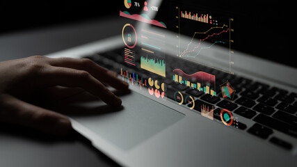 A close-up of a hand on a laptop featuring vibrant data visualization elements like graphs and charts. Ideal for themes of technology, analysis, and business insights. Impute