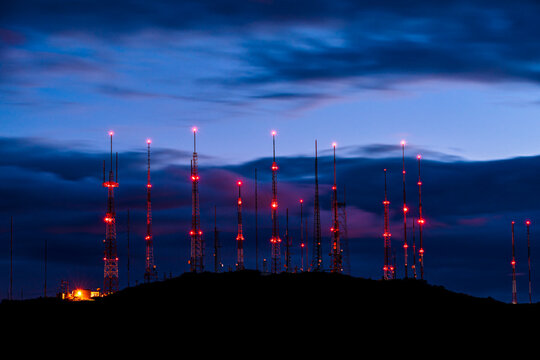 Communications towers on a mountain peak at dusk