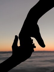 Silhouette of a father holding his children at sunset moment. Happy fathers day. Guidance, connection, protection, love and care. Serene sunset moment. Landscape scenery with adult and child hands.
