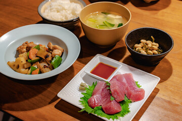 Japanese dinner with tuna sashimi, stir-fried chicken and vegetables, simmered beans, rice and miso soup
