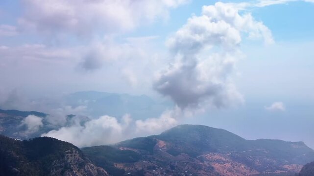 aerial footage showcasing the stunning natural beauty of Kelebekler Vadisi Butterfly Valley and the majestic Babadag mountains in Fethiye, Turkey. This panoramic view captures the lush landscapes, dra