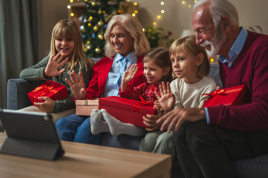 Grandparents and grandchildren celebrating christmas with virtual video call - Powered by Adobe