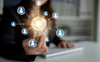A professional individual presents a glowing lightbulb as a metaphor for innovative ideas, surrounded by network icons, illustrating essential connections in modern business. Crux