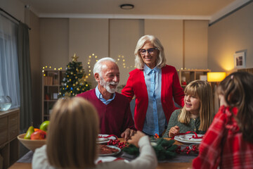 Grandparents and children celebrating holiday christmas dinner together