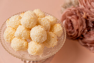 Delicious coconut balls arranged on a vintage glass plate, surrounded by soft pastel colors, creating an inviting and elegant dessert presentation for special occasions