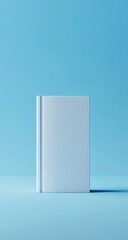 A vertically-oriented close-up shot of a blank, white book standing upright on a light blue background.  A slight shadow is cast to the right
