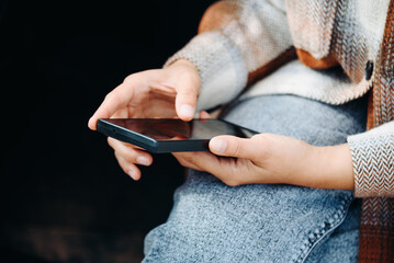 young woman holds smartphone in hands, sitting in car, travel blogger, close-up view, no face