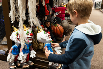 A child chooses a evil clown toy in a store for halloween