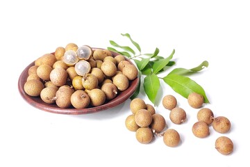 Fresh longan fruit with leaves in clay plate. Isolated on white background with copy space. Tropical Asian fruit. Suitable for editing and used for food and agriculture advertising.