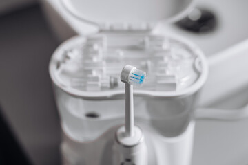 A home water flosser for teeth and oral care, placed in a bathroom interior. Concept: a modern and efficient solution for daily oral hygiene.