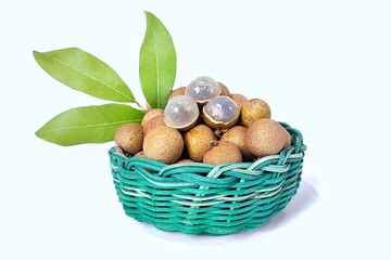 Fresh longan fruit with leaves in green wicker bamboo basket. Isolated on white background with copy space. Tropical Asian fruit. Suitable for editing and used for food and agriculture advertising.
