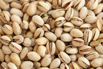 Tasty unpeeled pistachios as background, top view flat lay background